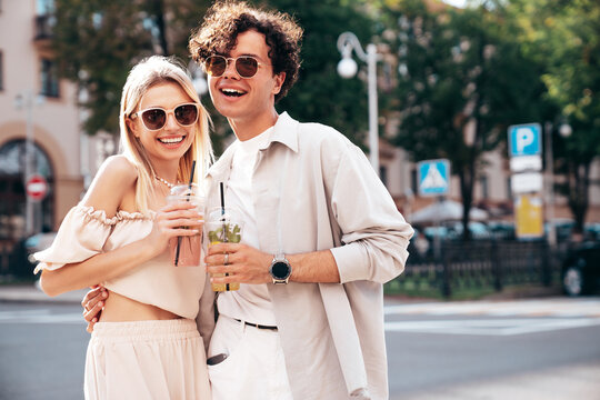 Young smiling beautiful woman and her handsome boyfriend in casual summer clothes. Happy cheerful family. Female having fun. Couple posing in the street background at sunny day. Take selfie photos