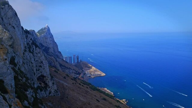 Aerial shot of an ocean with a hill cliff during daytime. Drone view.