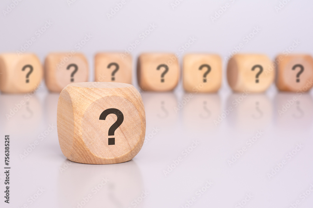 Aufkleber in the foreground is one wooden cube with a question mark and a reflection from the table surface. i