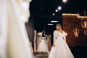 A beautiful bride is trying on a wedding dress in a store