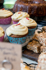 Cupcakes decoder with cream on top in a coffee shop counter.