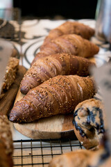 Freshly baked croissant on top of a baking tray. Coffee shop counter. 