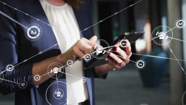 Animation of network of connections with icons over caucasian casual businesswoman using tablet