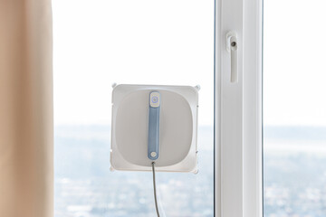 Window cleaning robot. Vacuum cleaner robot cleaning window on against sky