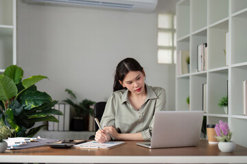 Businesswoman using laptop computer work from home in room. freelance, green room area, lifestyle concept