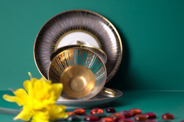 Close-up of old porcelain cup and plate isolated on green background