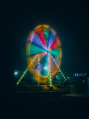 The ferris wheel in motion at night in a park