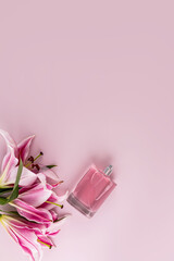 Elegant bottle of cosmetic spray or women's perfume on pastel vertical background with delicate lilies. A copy space. Blank layout for product.