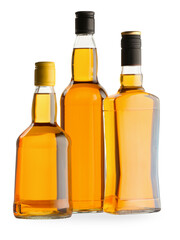 Different sorts of whiskey in glass bottles isolated on white