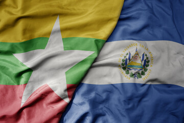 big waving national colorful flag of el salvador and national flag of myanmar .