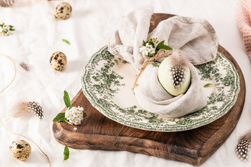 Stylish Easter brunch table setting with egg in easter bunny napkin.