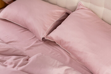 pale pink satin bed linen and pillows