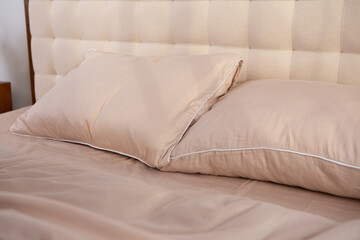 Fototapeta na wymiar light beige satin bed linen and pillows
