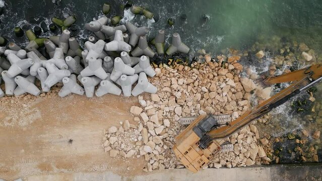 A long line of concrete blocks stretches across the sandy beach, creating a visible boundary on the shore.
