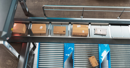 Recyclable Cardboard Box Being Transported on a Conveyor Belt in a Modern Logistics Center. Parcel...