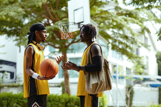 Cheerful friends talking after game of streetball