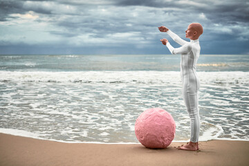 Full length portrait of hairless girl with alopecia in white futuristic suit standing on sea beach...