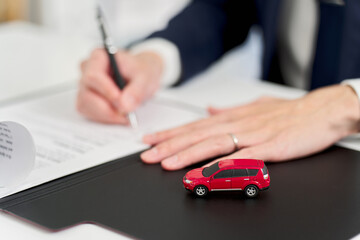 自動車の契約書にサインをするビジネスマン