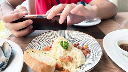 spaghetti carbonara, focusing on the hand taking a shot 