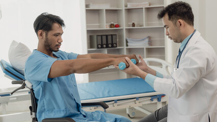 Physical therapist doing physical therapy on male patient with muscle injury in arm, healthy...