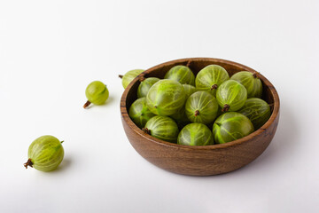 Fresh green gooseberry berries on a white background