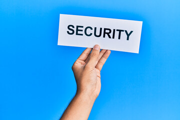 Hand of caucasian man holding paper with security word over isolated blue background