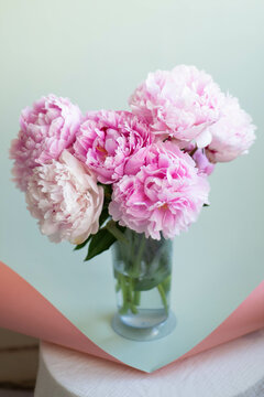 pink flowers in vase and mint color paper background
