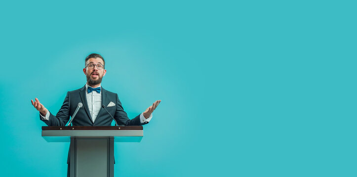 homme en train de faire un discours derri&egrave;re un pupitre - fond bleu