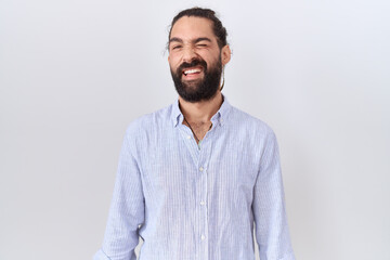 Hispanic man with beard wearing casual shirt winking looking at the camera with sexy expression,...