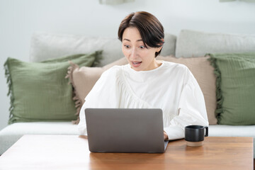 Naklejka premium パソコンを見て驚く女性