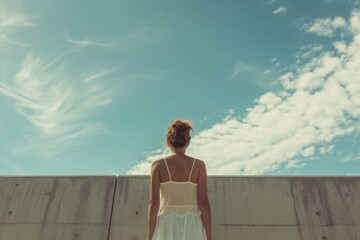 Fototapeta premium Woman in White Dress Standing Before Wall