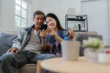 Retired elderly couple looking at mobile phone together, shopping online