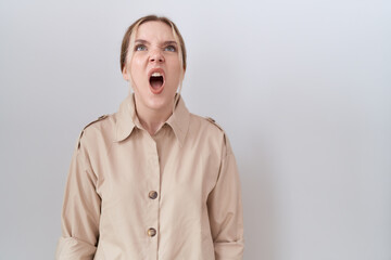 Young caucasian woman wearing casual shirt angry and mad screaming frustrated and furious, shouting...