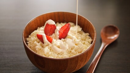 Bowl of cottage cheese adorned with strawberries drizzled with dollop of sour cream Dive into...