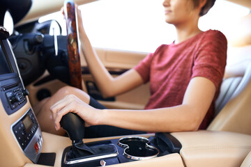 Closeup, gear and woman in luxury car and driving with steering wheel and travel with...