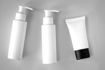 White bottles and tube of cosmetic products background