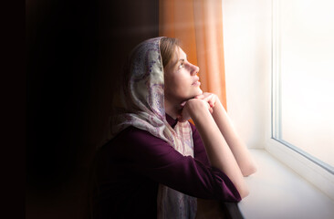 Girl praying by the window