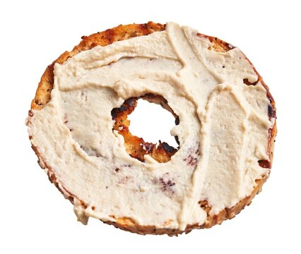 A single toasted bagel covered with cream cheese, isolated on a white background, showcasing a popular breakfast choice.