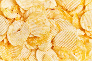 Close-up of rippled potato chips, showcasing their textured surface and golden yellow color.