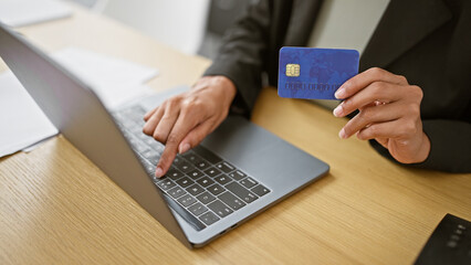 Hands of woman business worker using laptop and credit card at the office