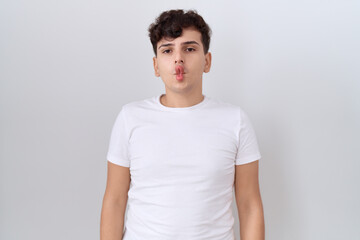 Young non binary man wearing casual white t shirt making fish face with lips, crazy and comical gesture. funny expression.