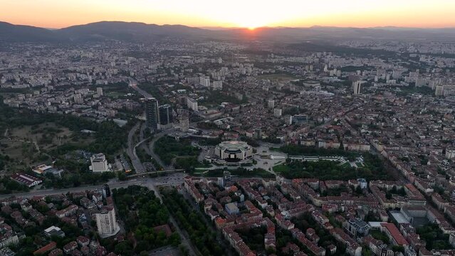 4K Aerial view of sunset or sunrise of the center of the capital of Bulgaria - Sofia. Architectural and emblematic buildings from the communist era, NDK - National Palace of Culture. Night lights
