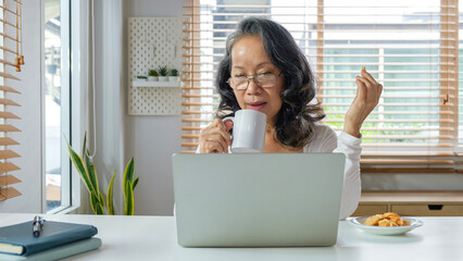 Portrait of calm senior woman drinking her morning coffee.