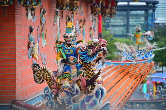 Taiwan - Jan 23, 2024: The photo shows a close-up of a detail on the roof of Songshan Ciyou Temple in Taipei, Taiwan. The detail shows a man with a dragon-like face riding on a dragon.