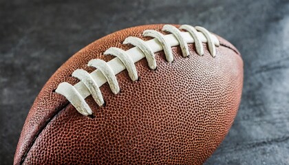 close up photo of laced leather ball for playing american football or rugby on black background