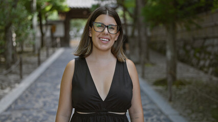 Joyful and confident, a beautiful hispanic woman in glasses stands by the serene ginkaku-ji temple,...