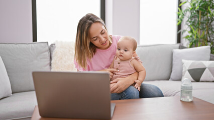 Mother and daughter's bond deepens, casually sitting on sofa at home, engaged in serious video call...
