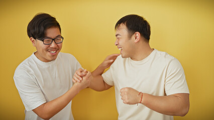 Two asian men in white shirts smiling and shaking hands against a yellow background, radiating a sense of friendship and companionship.