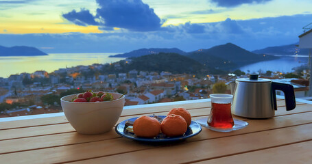 Scenic romantic tea party, fresh fruits, nobody, terrace with seaside town view
