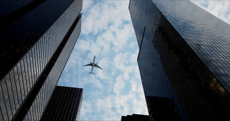 Bottom view of a passenger long-haul aircraft liner flying over skyscrapers in the business center...